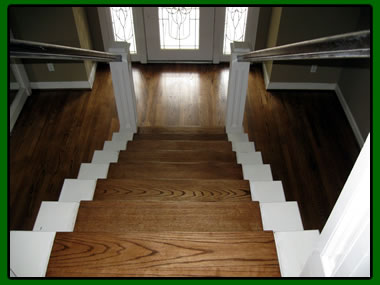 Custom oak stair treads and hardwood landing Custom oak stair treads with white risers and matching hardwood landing in a Houston home