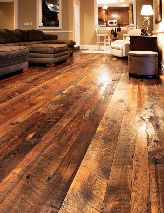 Rustic hand-scraped hardwood flooring Rustic hand-scraped wood flooring in a living room with varied warm plank tones
