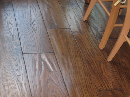Hand-scraped hardwood floor in a Houston dining area Dark hand scraped hardwood floor with oak grain in a Houston dining area
