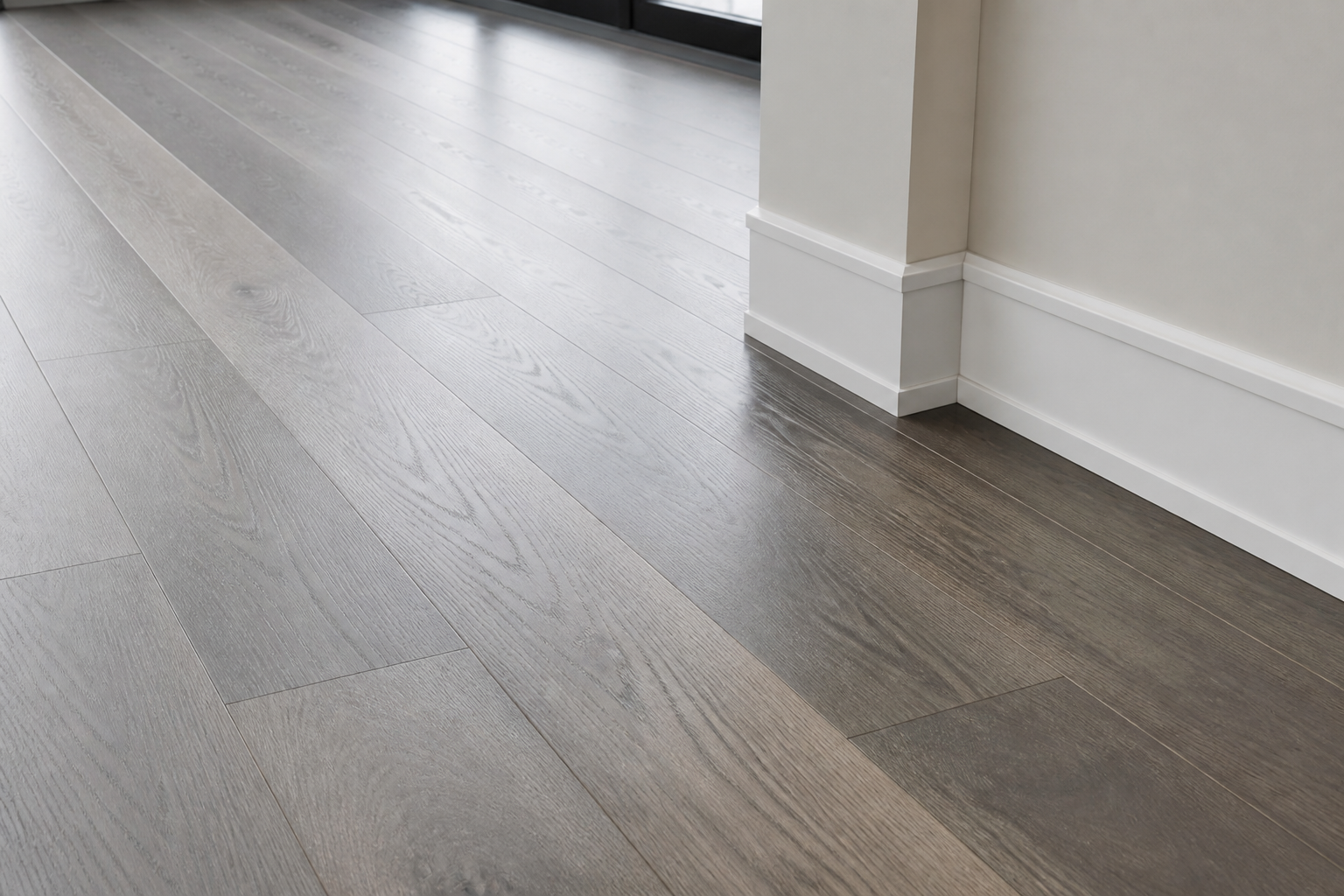Modern gray hardwood floor detail with matte finish, visible grain, and clean baseboard transition