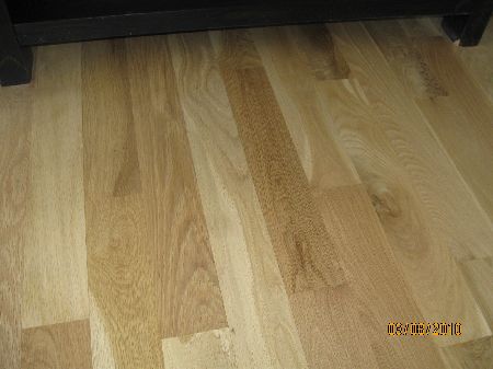 Light natural white oak hardwood floor with a clear water-base finish beside a modern railing in a Houston home